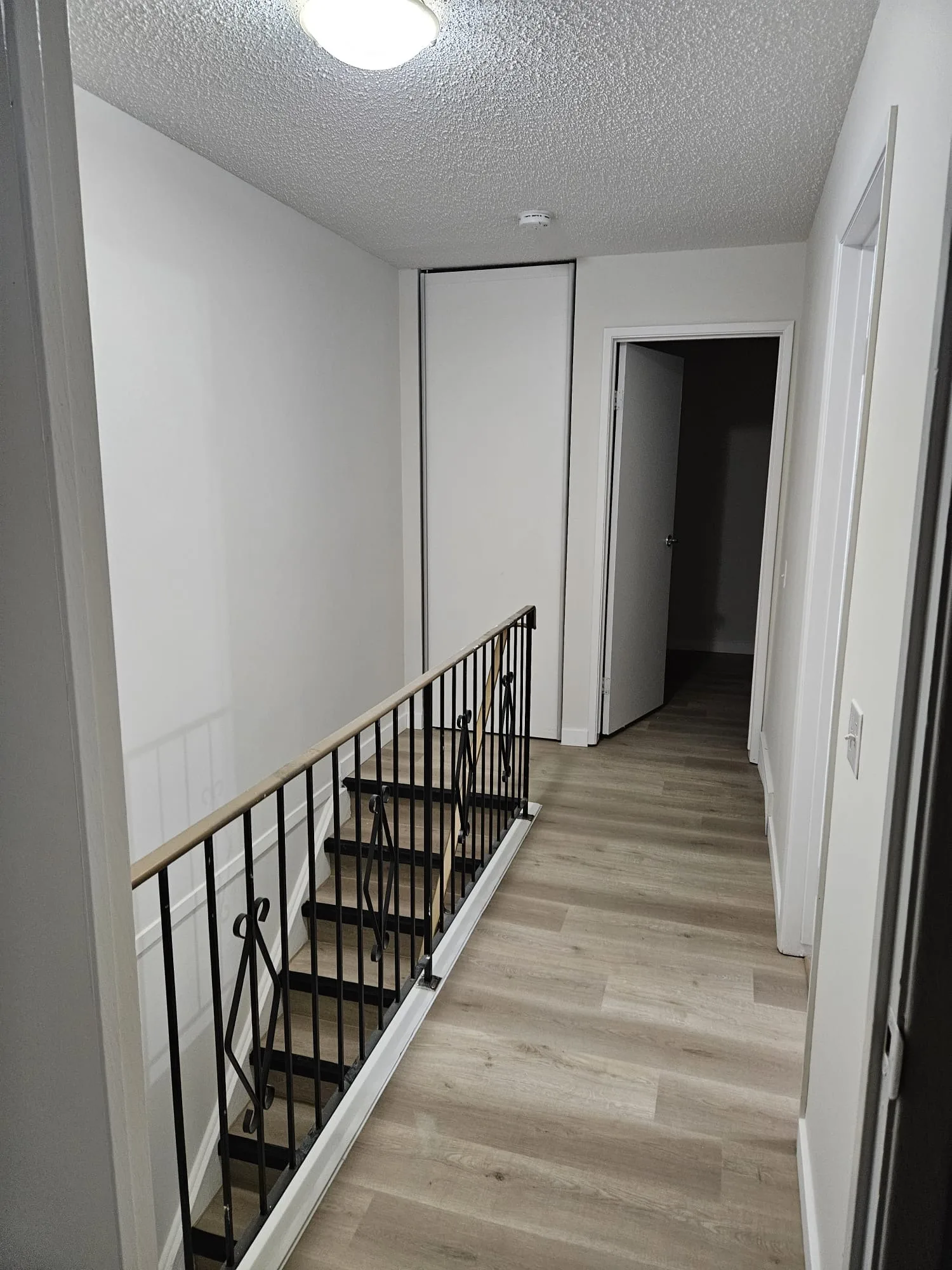 Lvp Hallway Staircase Iron Railing — Stampede Flooring Calgary