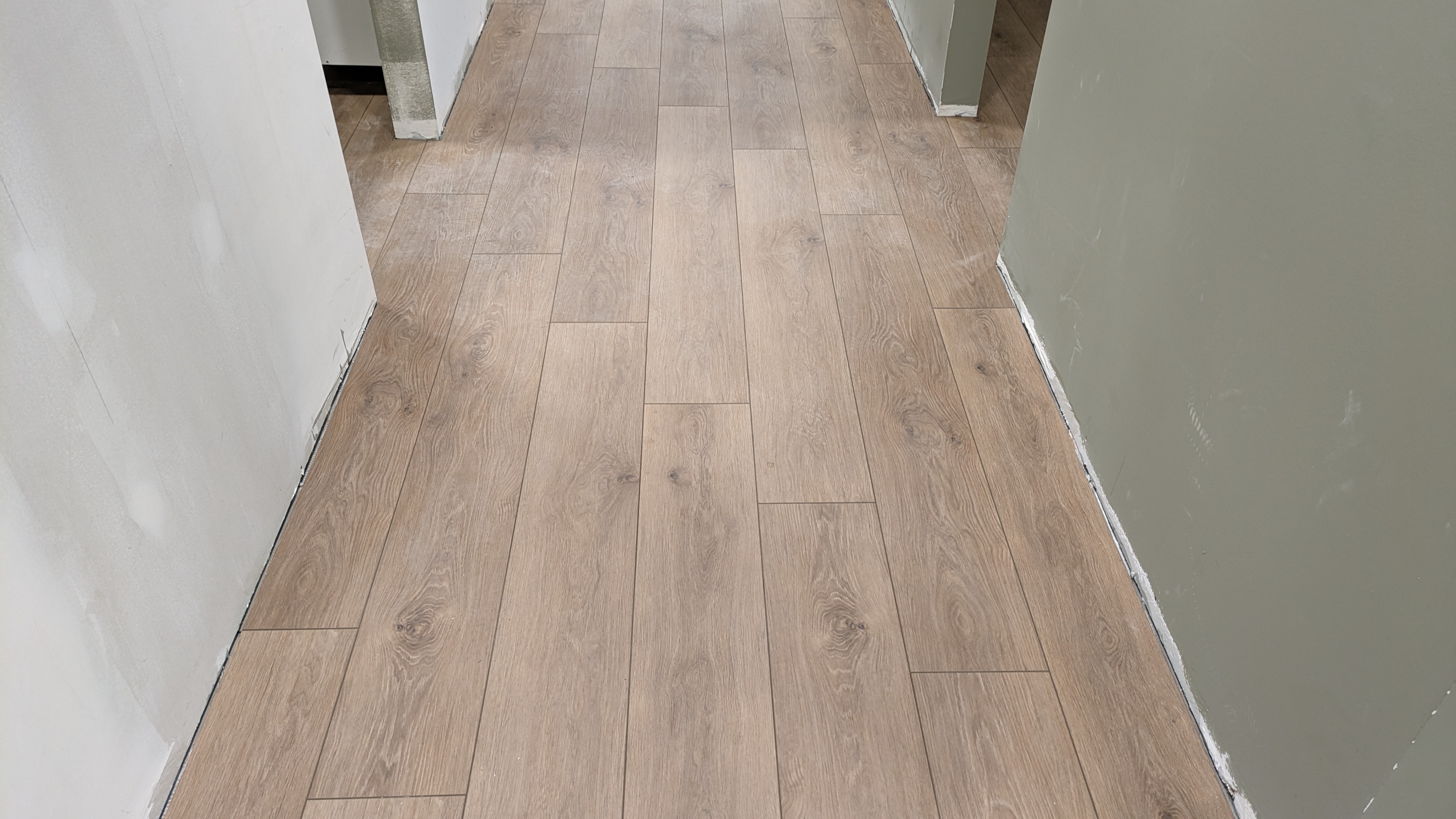 Waterproof LVP flooring in a Calgary basement — warm wood-look luxury vinyl plank