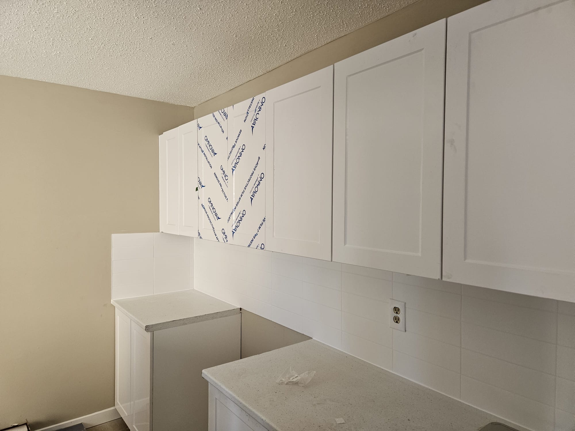 Kitchen flooring renovation in SW Calgary — new porcelain tile replacing old laminate