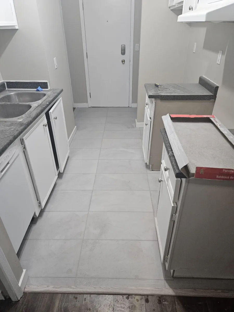 Kitchen flooring renovation in SW Calgary — new porcelain tile replacing old laminate