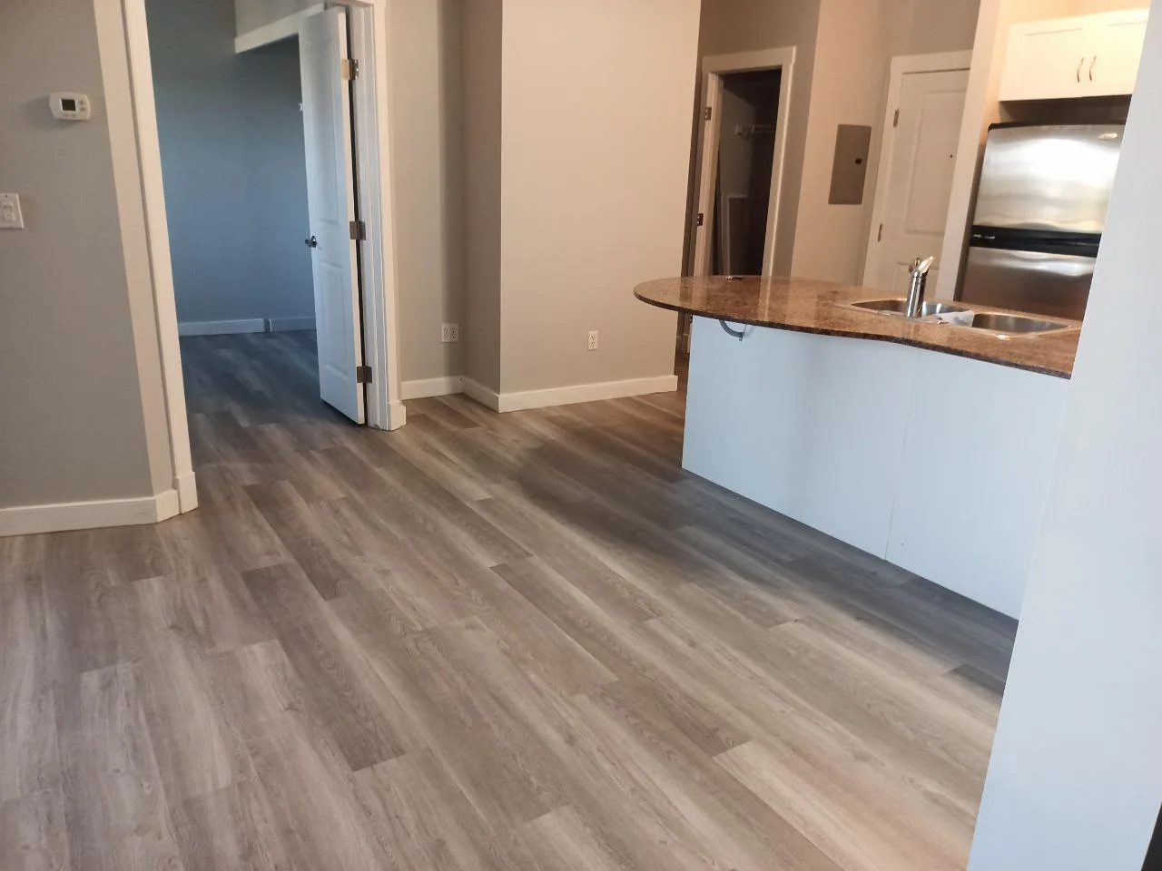Kitchen flooring renovation in NW Calgary — large format porcelain replacing old tile